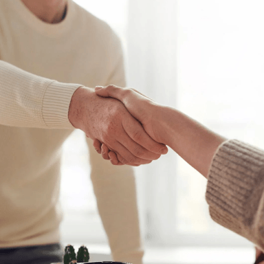 Two person sharing a handshake after a successful business deal with the title that says Success Stories with Mayk